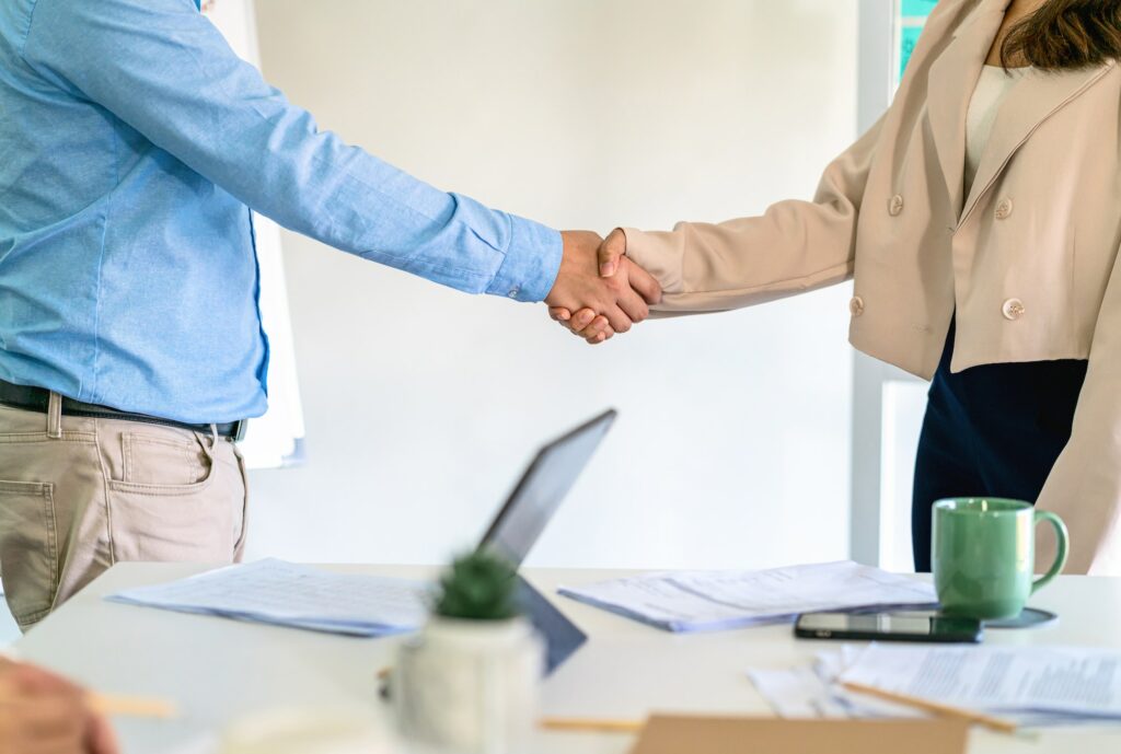 Closeup handshake of asian partner businessman and businesswoman in modern office after deal